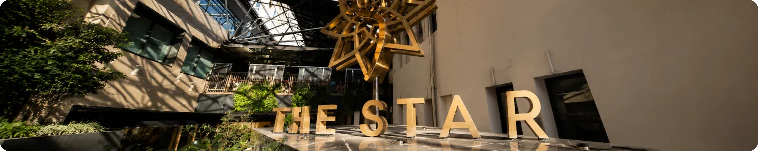 The Star Sydney atrium with gold signage and star sculpture under a glass roof, shown in a wide editorial banner
